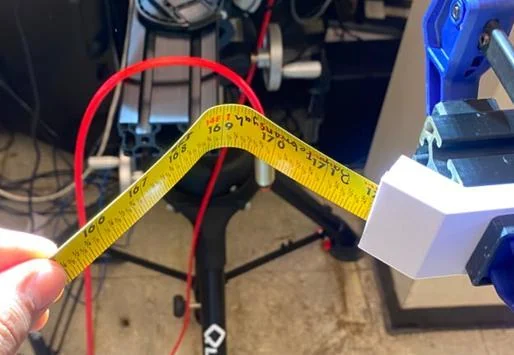 Thin steel tape spring bent in a measurement fixture